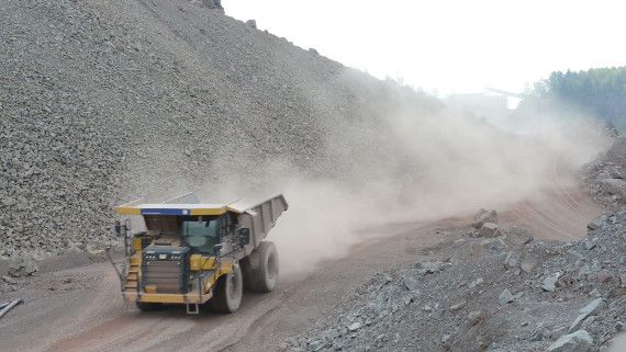 yellow truck driving on dusty road